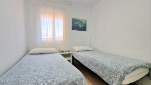 two twin beds in a room with a window at Apartamento Fuengirola Costa in Fuengirola +77 photos