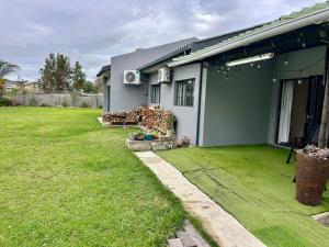 a house with a green lawn in front of it at Bamboo in George +5 photos