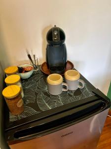 a coffee pot and two cups on top of a stove at Bamboo in George