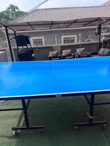 a blue ping pong table in front of a table at Stone and Beam apartment in Abuja
