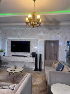 a living room with a couch and a table at Stone and Beam apartment in Abuja