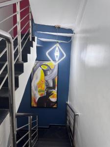 a stairwell with a painting on the wall at Stone and Beam apartment in Abuja