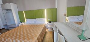 two beds in a room with green and white at Hotel La Falena in Cervia
