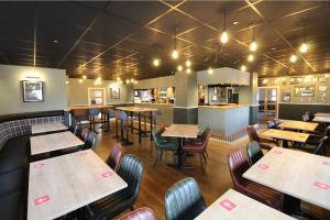 a restaurant with tables and chairs and a kitchen at Bronte Breaks in Haworth