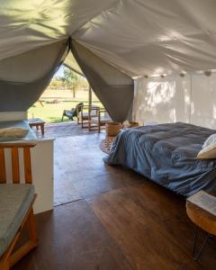a bedroom with a bed in a tent at moraycamp in San Andrés de Giles +32 photos