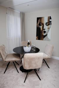 a dining room with a black table and two chairs at Hotel M in Zaton