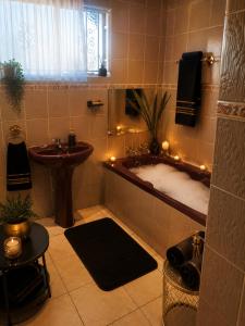 a bathroom with a tub and a sink with lights at Bushman Kraal Backpackers in Soweto