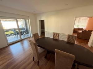 a dining room with a black table and chairs at Apartmani L&V in Kula