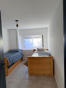 a small bedroom with two beds and a window at DUPLEX Parque in Azul +2 photos