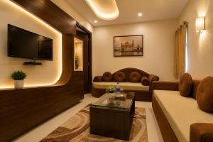 a living room with a couch and a tv at Hotel Nayyar Inn Near Golden temple in Amritsar