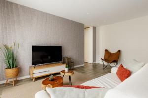 a living room with a flat screen tv on a wall at Shellter Apartments by the sea in Vieira de Leiria