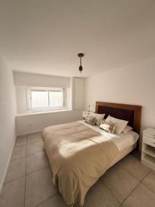a large bed in a white room with a window at DUPLEX Parque in Azul