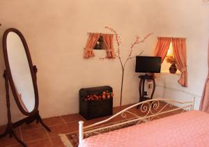 a bedroom with a bed and a mirror and a television at Trullo Salento in Galatone