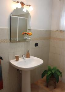 a bathroom with a white sink and a mirror at Trullo Salento in Galatone