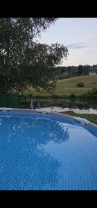 a blue swimming pool with a view of a field at Vikendica Stanković in Šipovo +19 photos