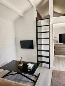 a living room with a table and a tv at Cabanoù Lodge & Spa in Messanges