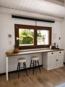 a kitchen with a counter with two stools and a window at Orizzonti in Ortona