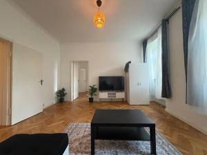 a living room with a table and a tv at Holstentor Apartment in Lübeck