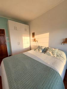 a bedroom with a large bed with a blue blanket at Casa Vista Pacífico in Concón +10 photos