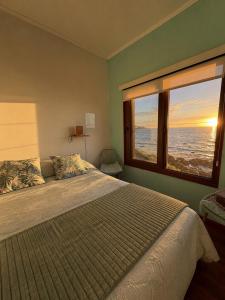 a bedroom with a large bed and a large window at Casa Vista Pacífico in Concón