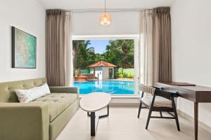 a living room with a couch and a table at Verano Hotel & Spa Arpora Goa in Arpora