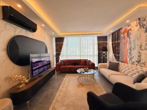 a living room with a couch and a tv at SA Apartments! 2BR Flat 100m to Cleopatra Beach in Alanya