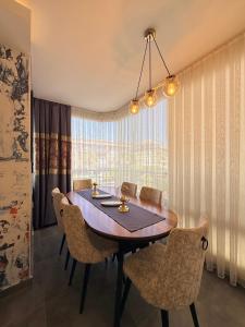 a dining room table with chairs and a large window at SA Apartments! 2BR Flat 100m to Cleopatra Beach in Alanya