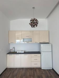 a kitchen with white cabinets and a white refrigerator at Haus am Strand in Bar +14 photos