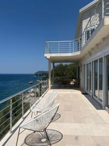 a balcony with two chairs and the ocean at Haus am Strand in Bar