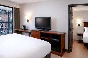 a hotel room with a bed and a flat screen tv at Clifton Victoria Inn at the Falls in Niagara Falls