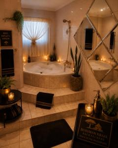 a large bathroom with a tub and a mirror at Bushman Kraal Backpackers in Soweto