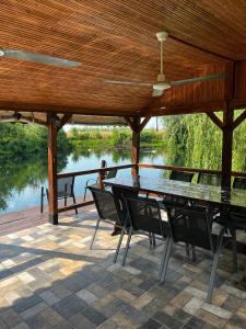 a table and chairs on a patio with a view of a river at Souvenir in Isaccea