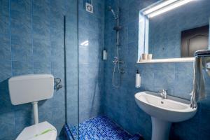 a blue tiled bathroom with a sink and a shower at Hotel Callatis in Neptun +41 photos