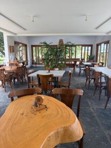 a dining room with tables and chairs and windows at Nazareth Cânion in Buriti dos Montes