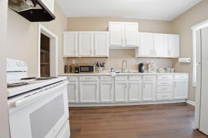a kitchen with white cabinets and white appliances at Group-Ready 6BR Gem in Central Lafayette in Lafayette
