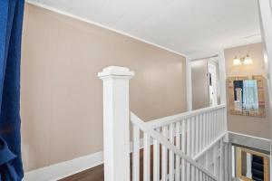 a white staircase in a home with a blue curtain at Group-Ready 6BR Gem in Central Lafayette in Lafayette
