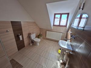a bathroom with a toilet and a sink at Pension Chalupka l with a panoramic view of Spiš Castle in Spišské Podhradie