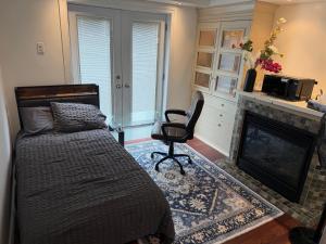 a bedroom with a bed and a chair and a fireplace at Your own home in Toronto
