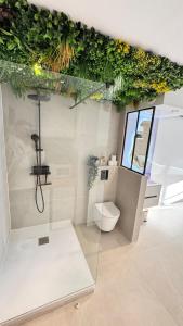 a bathroom with a toilet and plants on the ceiling at Studio cosy Plage à pied Parking in La Grande Motte