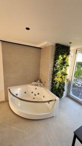 a large white bath tub in a room with a large window at Studio cosy Plage à pied Parking in La Grande Motte