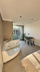 a large bathroom with a bath tub next to a bed at Studio cosy Plage à pied Parking in La Grande Motte