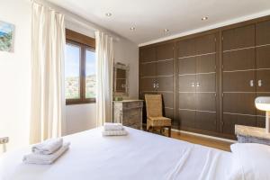 a bedroom with a white bed and a window at Sunny Holidays Mojácar Pool House in Mojácar