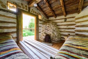 two beds in a room with a stone fireplace at Doru' Bucovinei in Moldoviţa