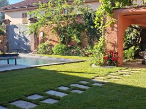 a backyard with a swimming pool and a house at Villa Lu alloggio con idromassaggio e piscina in Carignano