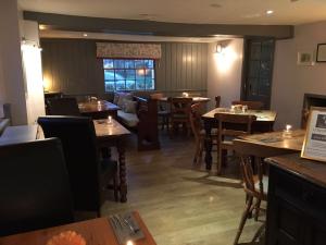 a restaurant with wooden tables and chairs and a window at The Tollgate Inn in Bradford on Avon