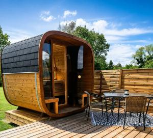 a circular wooden cabin with a table on a deck at Le Clos des Chenevières in Rainville