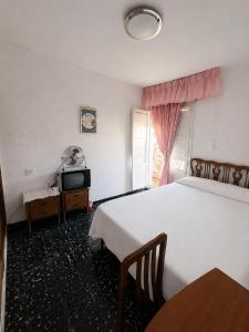 a hotel room with a bed and a tv at Leidy in Alicante