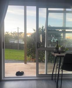 a glass door with a cat sitting on a wooden floor at Oasis in onerahi in Whangarei
