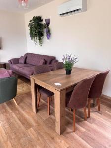 a living room with a wooden table and a couch at Pollux Astra Bay in Lepetani +9 photos
