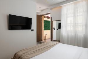 a bedroom with a bed and a flat screen tv at Karavel Suites - Old Town Boutique Rooms in Rhodes Town
